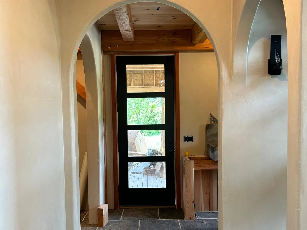Arched openings finished in American Clay natural plaster over a slate floor
