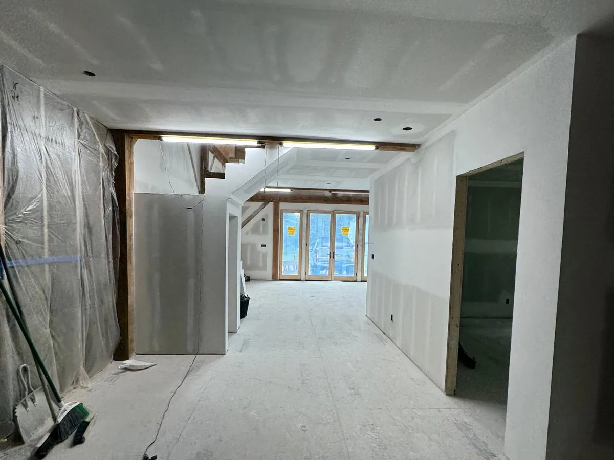 New construction interior with drywall hung and taped through to a bright window wall