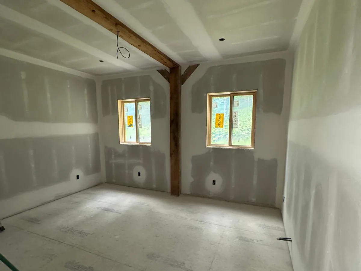 Drywall hung and taped around timber posts with twin windows