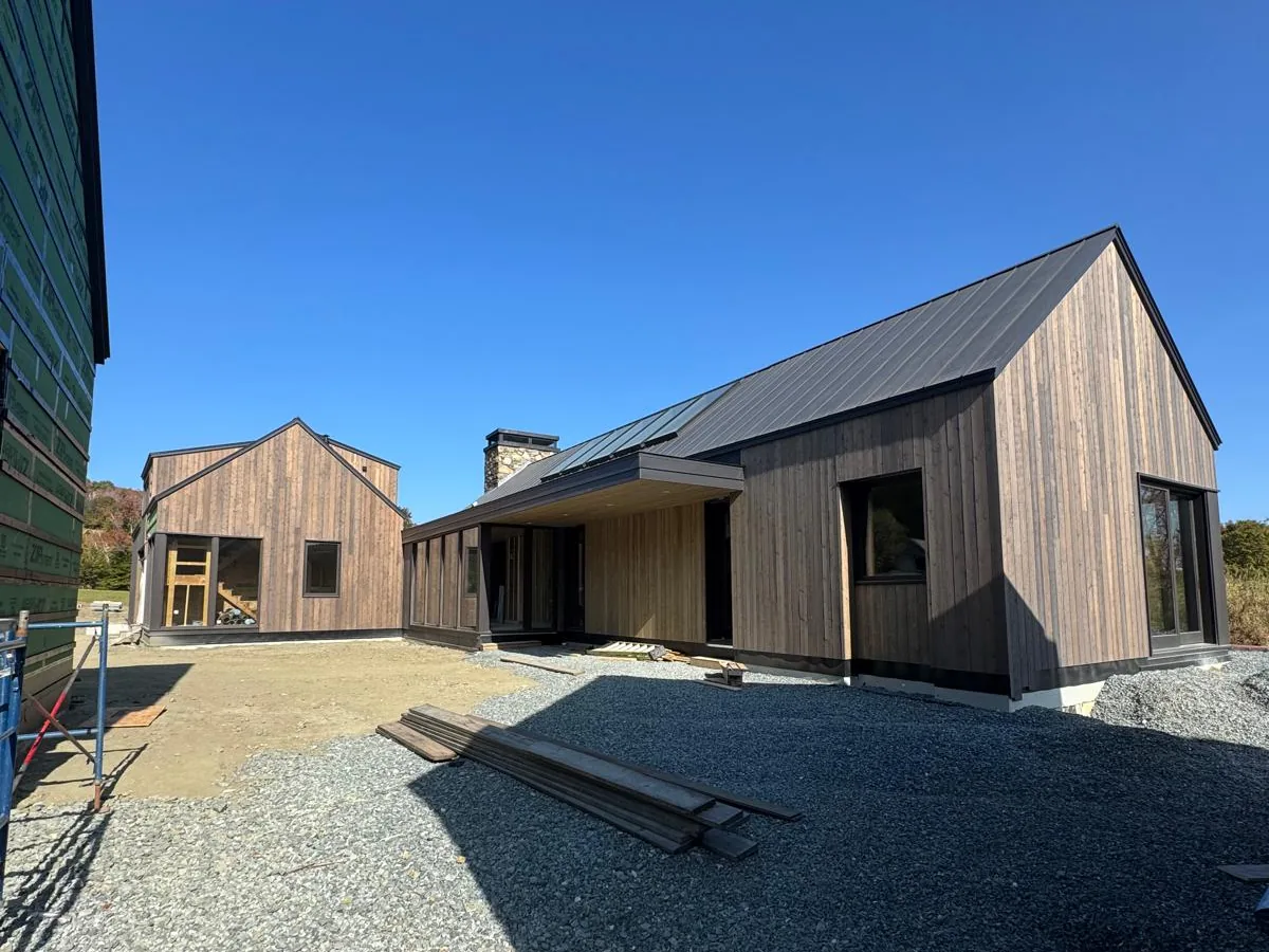 Two modern barn forms in timber cladding on a finished site