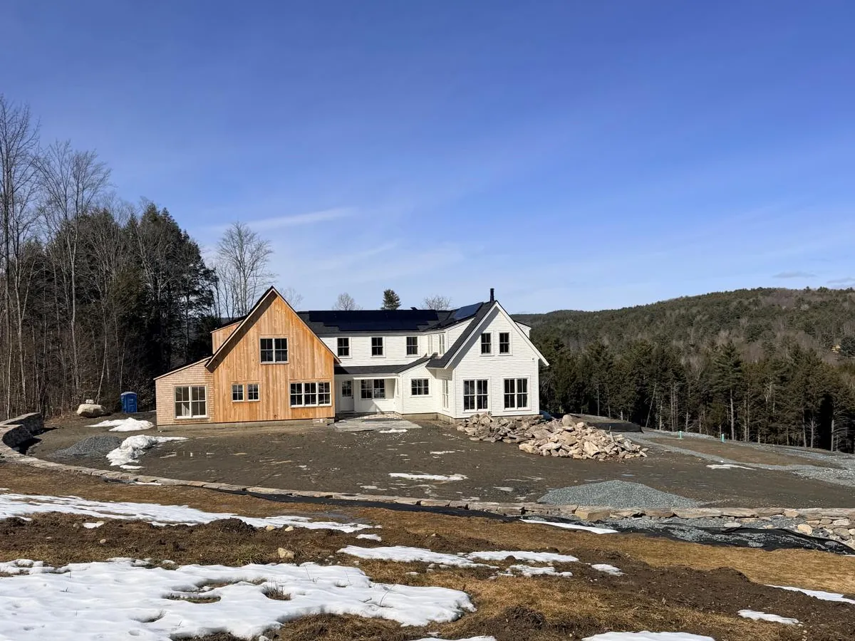 New farmhouse on a hillside site with the exterior complete
