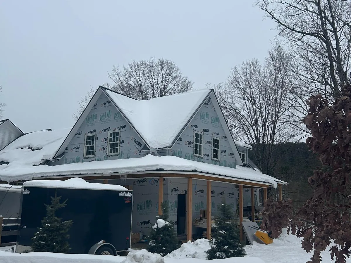 Gabled house under construction in deep winter snow