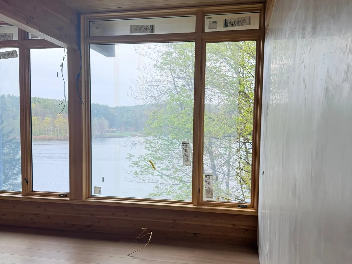 Finished room with plaster walls and wood trim looking out over a lake