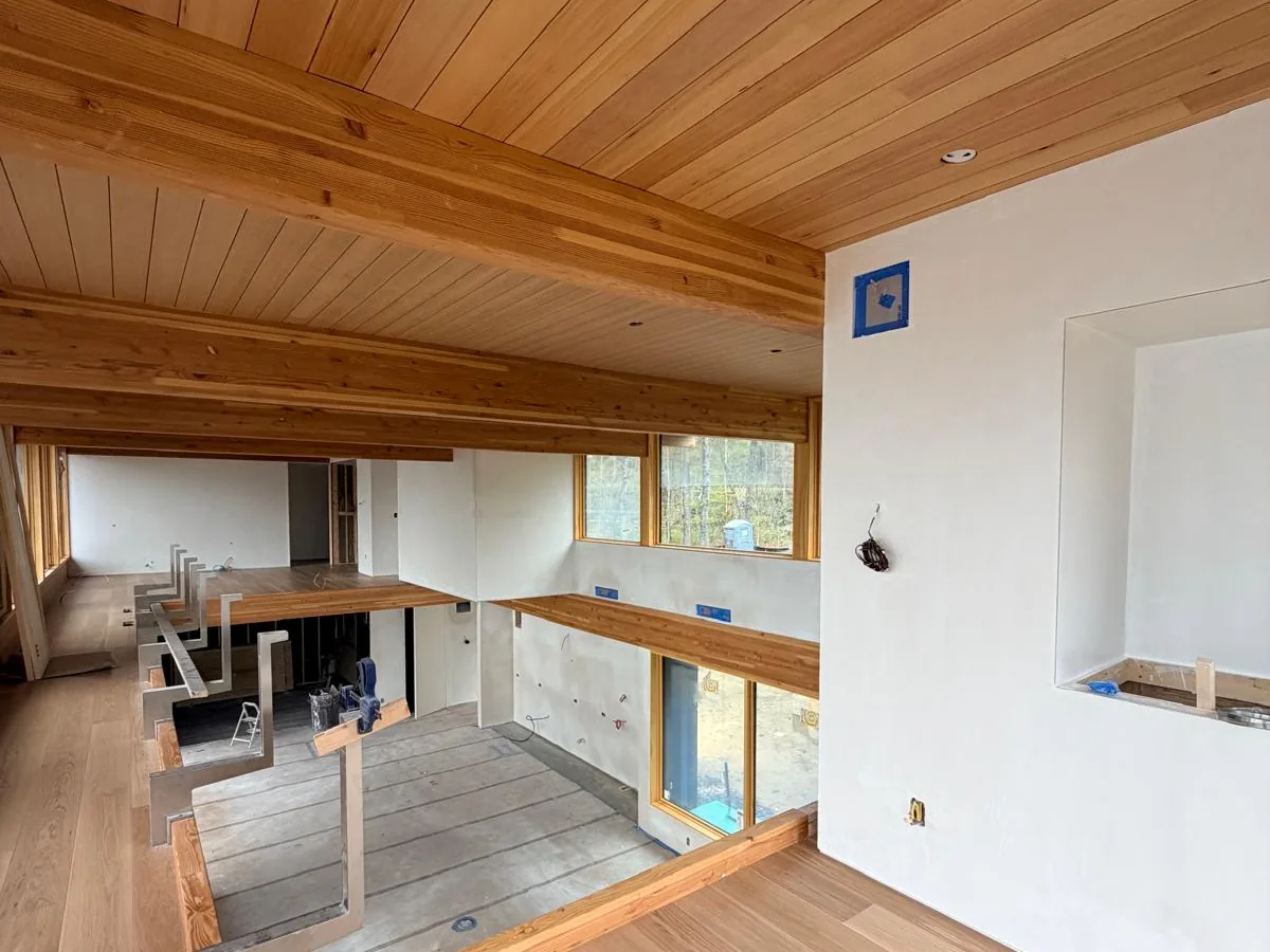 Finished room with white plaster walls under a cedar ceiling