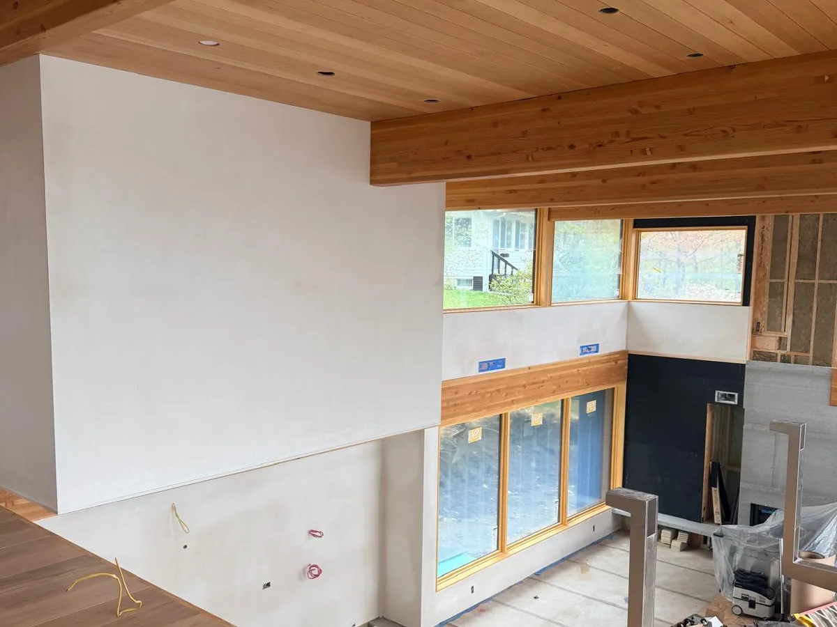 Finished interior with plaster walls, cedar ceiling and a corner window