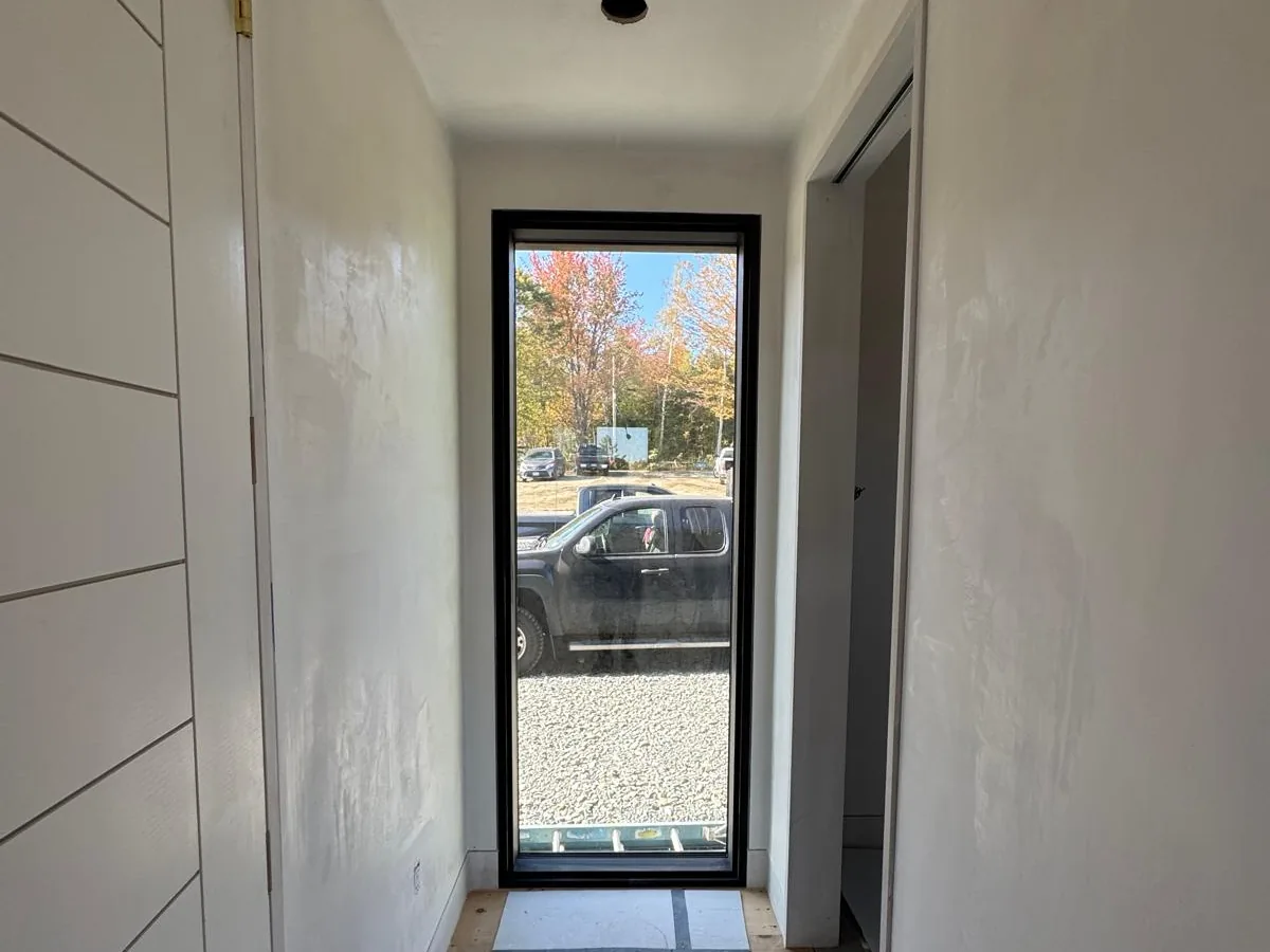 Finished entry hall with shiplap panelling and a glass door to the drive