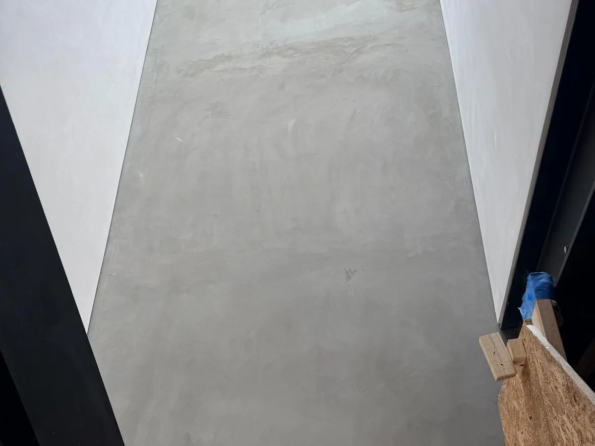 Full height grey microcement panel running between two floors