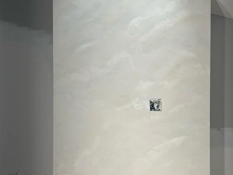 Pale polished plaster panel finished smooth, running floor to ceiling