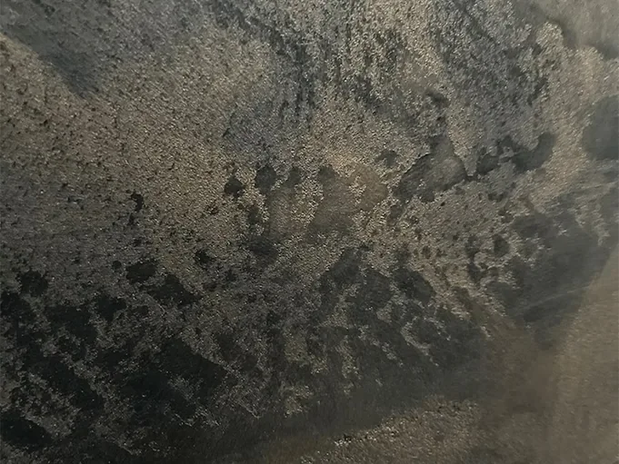 Macro of a metallic effect plaster surface with heavy mottled texture